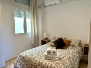 una camera da letto con un letto con asciugamani sopra di Apartamento insonorizado con vistas a plaza Bib Rambla a Granada Altre 43 foto