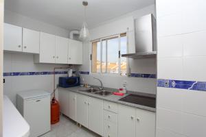 a kitchen with white cabinets and a sink at Bolnuevo Apartment in Bolnuevo
