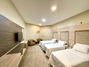 a hotel room with two beds and a flat screen tv at فندق دلسDELS HoTEL in Tabuk +32 photos