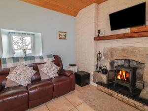 a living room with a couch and a fireplace at Dan White's Cottage in Newry