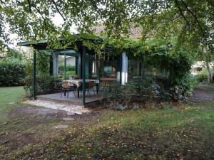 ein Pavillon mit Tisch und Stühlen in einem Hof in der Unterkunft Villa Mimosa Comfortable holiday residence in Lacanau