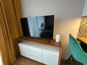 a flat screen tv sitting on top of a dresser at GiorgiaTerrasedHouse in Raadi