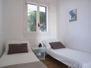 two beds in a room with a window at Appartamento Bellavista - Direzione Salento in Torre dell'Orso