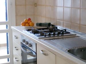 a kitchen with a stove and a bowl of fruit at Appartamento Bellavista - Direzione Salento in Torre dell'Orso