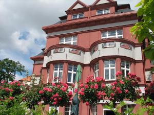 a pink building with flowers in front of it at Hotel Villa in Prague