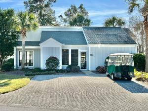 a white house with a golf cart parked in the driveway at 750 Sandpiper in Destin