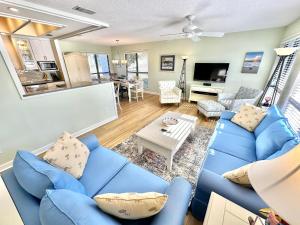 a living room with a blue couch and a table at 750 Sandpiper in Destin
