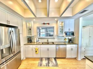 a kitchen with white cabinets and a stainless steel refrigerator at 750 Sandpiper in Destin