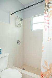 アグアダにあるOcean Terrace 202 a 4 min walk to Sandy Beachのトイレと窓のある白いバスルーム +5枚の写真