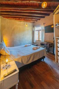 a bedroom with a bed and a desk and a window at Terracota Eco-Casa Intiyaco 6 Pax in Atos Pampa