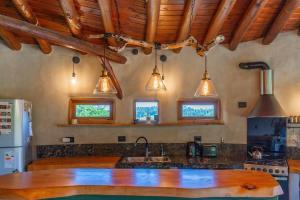 a kitchen with a wooden counter and pendant lights at Terracota Eco-Casa Intiyaco 6 Pax in Atos Pampa