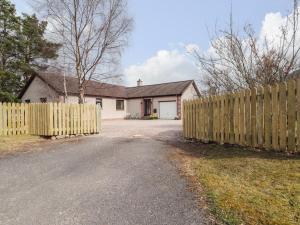 a wooden fence in front of a house at Millview in Boat of Garten