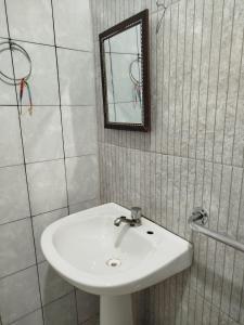 a bathroom with a white sink and a mirror at Lar da Elis in Riacho Fundo