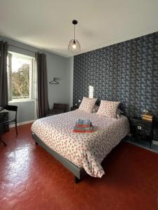 a bedroom with a bed with a patterned wall at Effets Personnels in Orange