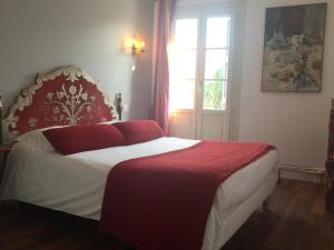 a bedroom with a red and white bed with a window at Hôtel des Templiers in Collioure
