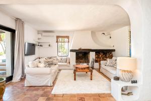 a living room with white furniture and a fireplace at Casa Amapola by Eivillas in Sant Josep de Sa Talaia
