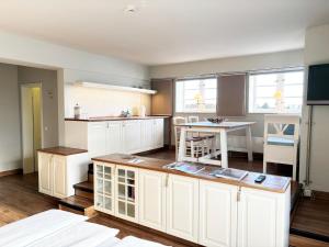 une cuisine avec des armoires blanches et une table dans l'établissement Pier 8 im Pierspeicher, à Kappeln