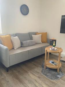 a living room with a couch and a table with a clock at Ferienwohnung im Zentrum mit Balkon und Parkplatz in Gmunden