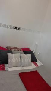 een slaapkamer met een bed met rode en witte kussens bij Le coquelicot in Maimbeville