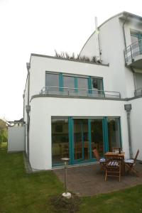 a white house with a table in front of it at Meerblick - Ostseebad Nienhagen in Ostseebad Nienhagen