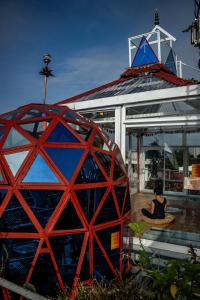 Una donna seduta su una panchina di fronte a un edificio di Mandala Yoga Hostel a Bogotá