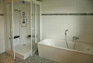 a white bathroom with a tub and a shower at Meerblick - Ostseebad Nienhagen in Ostseebad Nienhagen +52 photos