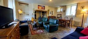 a living room with a couch and a dining room at L' Anpeg, gîte dans le Cotentin jusqu'à 8 personnes in Besneville
