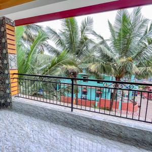 balcone con vista su un resort con palme di RONZ VISTA DA PRAIA a Calangute