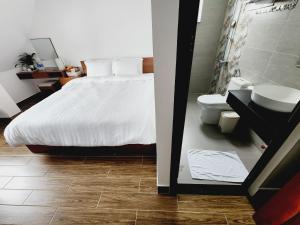 a bedroom with a bed and a sink and a toilet at Happy Bun Hotel Da Lat in Da Lat +51 photos