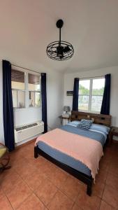 a bedroom with a bed and two windows at Costa Ensenada Penthouse 505 across the street from Balneario beach in Rincon +18 photos