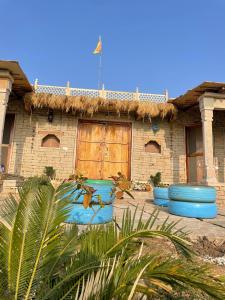 a house with blue barrels in front of it at Virasat homestay in Chanderi
