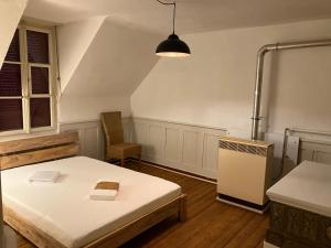 ブルクドルフにあるOld Charming Rustic Swiss Mansarde 60m2 Center Burgdorf Parking Small Bathのベッド1台と冷蔵庫が備わる客室です。