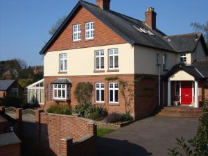 a red and white house with a red door at Stoneborough House B&B in Budleigh Salterton