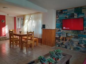 La Casa de los Gisitos في ريو سيبالوس: غرفة طعام مع طاولة وتلفزيون على الحائط