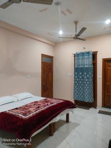 FaizābādにあるGaurav Orchid Homestayのベッドと天井扇風機のある寝室