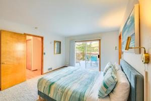 a bedroom with a bed and a sliding glass door at Fish and Bike Lake Pend Oreille Gem with Hot Tub! in Athol +37 photos