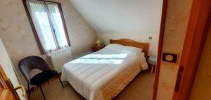 a small bedroom with a bed and a window at Le logis de l'Ajolaise in Vielle-Aure