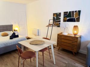 ein Schlafzimmer mit einem Bett und einem Tisch und Stühlen in der Unterkunft Le Confetti ! in Sète