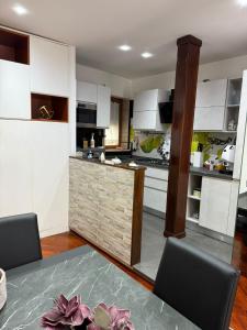 a kitchen with white cabinets and a table with chairs at Marebleuhouse in Naples
