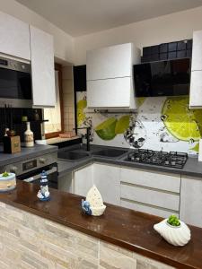 a kitchen with white cabinets and a stove top oven at Marebleuhouse in Naples +4 photos