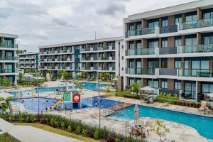 an apartment building with a pool and a playground at Makia By MAI in Porto De Galinhas