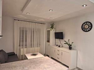 a living room with a couch and a clock on the wall at Kornel's Apartament in Jelenia Góra