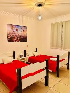 two beds in a room with red sheets at LAquolina in Socorro