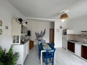 una cucina e una sala da pranzo con tavolo e sedie di Villa Malsine a Marzamemi