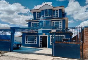 a blue house with a gate in front of it at Cabaña Rural BlueHousePaipa in Paipa
