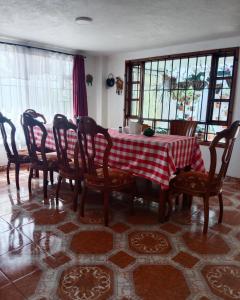 a dining room table with a red and white checkered table cloth at Cabaña Rural BlueHousePaipa in Paipa +28 photos