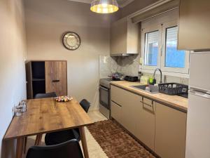 a kitchen with a wooden table and a counter top at Mountain View Apartment Pozar in Polykárpion
