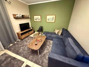 a living room with a blue couch and a table at Mountain View Apartment Pozar in Polykárpion