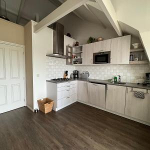 a kitchen with white cabinets and a counter top at Herenstraat 55 in Den Hoorn