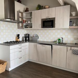 a kitchen with white cabinets and a counter top at Herenstraat 55 in Den Hoorn +19 photos